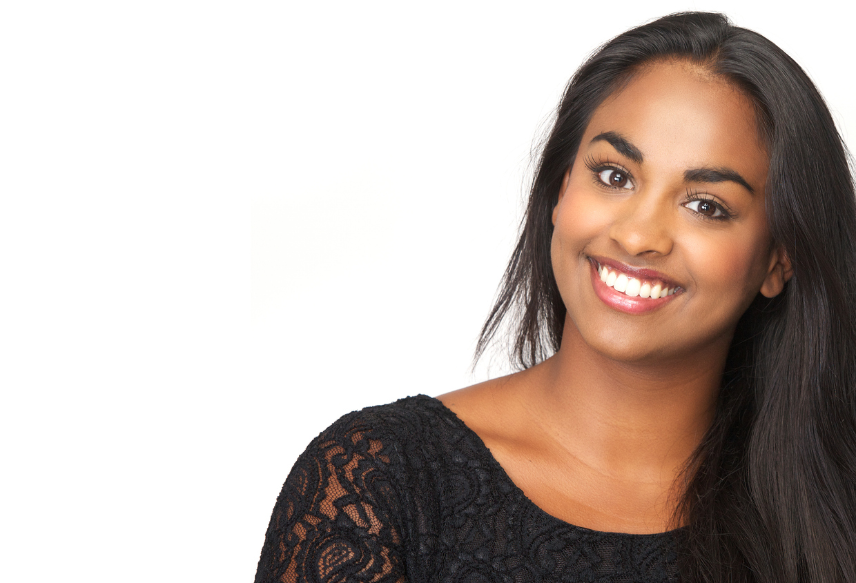Closeup portrait of a beautiful woman smiling on isolated white background - copy space